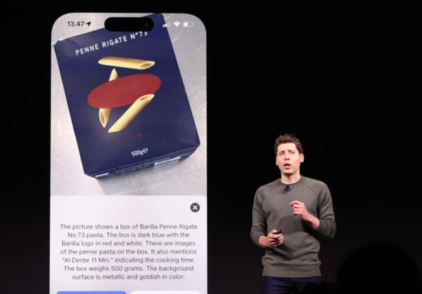 Sam Altman in front of a mock-up of a phone showing a box of pasta